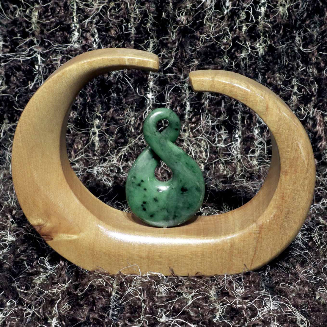 Carved jade crossover mounted on a kauri stand