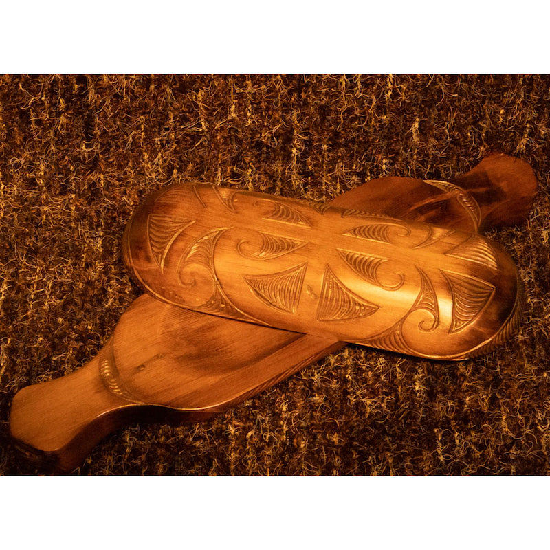 Open wooden waka huia with carved lid